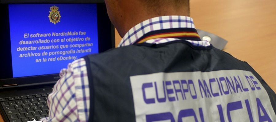 Un agente de Policía revisa un ordenador en el marco de una operación contra la pornografía