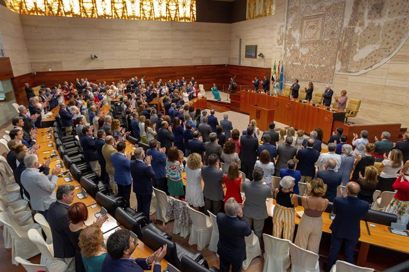 Los asistentes al acto institucional en la cámara Legislativa extremeña de pie escuchando el himno de Extremadura.